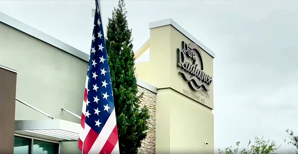 The Pure Radiance Medical Spa building in Tyler, Texas, its sign beside an American flag