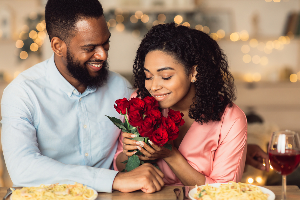 Woman smells roses before leaving for a romantic dinner date. Woman smells roses before leaving for a romantic dinner date.